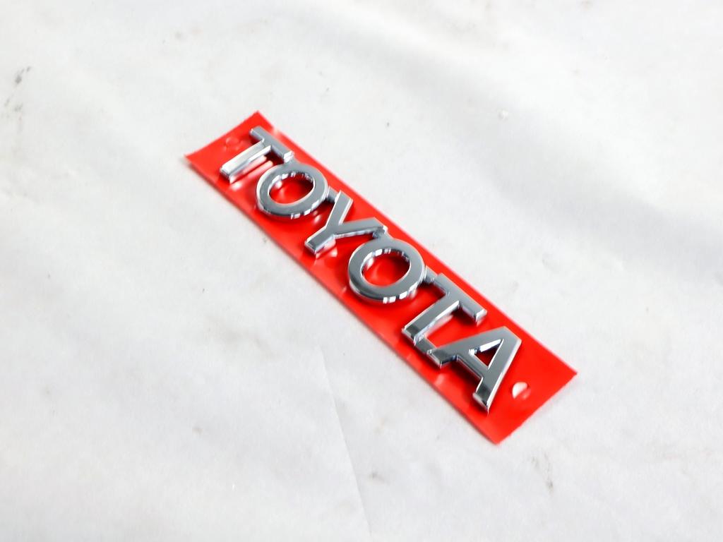 75446-0D040 STEMMA FREGIO LOGO EMBLEMA "TOYOTA" PORTELLONE COFANO POSTERIORE BAULE TOYOTA YARIS P13 1.5 I 55KW AUT 5P (2014) RICAMBIO NUOVO